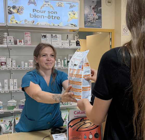 V&eacute;t&eacute;rinaire dans la boutique de la clinique qui donne un produit v&eacute;t&eacute;rinaire.